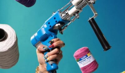 a woman hand holding a tufting gun